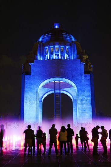 People watching the light show and fountains in front of the Monument to the Revolution