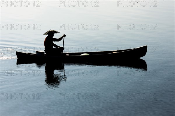 Fisherman in a small wooden boat