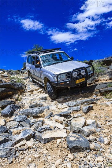 SUV driving down steep rock steps