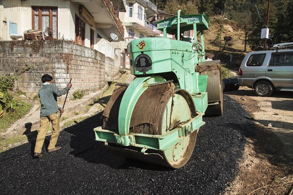 Road construction workers laying tar