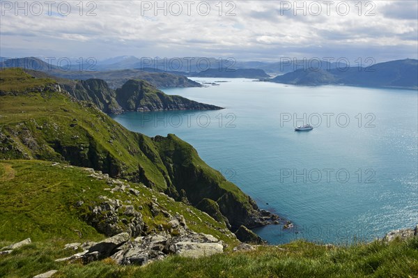 Cruise ship in a bay off the rugged cliffs of Runde island