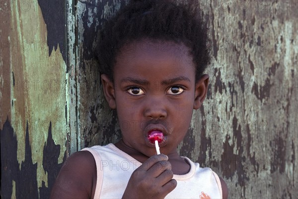 Local girl licking a red lollipop