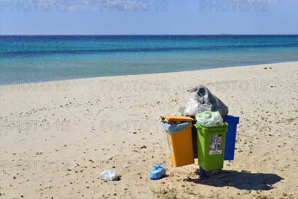 Overflowing trash cans on the beach