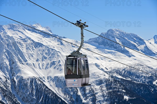 Gondola of the Moosfluh cable car in front of the snowy mountain range of the Valais Alps