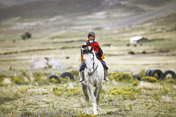 Boy from the Puruha people riding on a horse