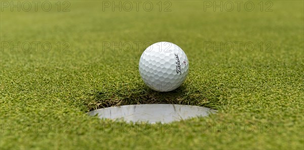 Golf ball rolling into the hole