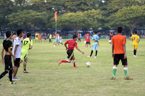 Teenagers playing football in a public park