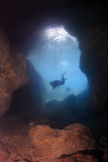 Diver looking into a cave