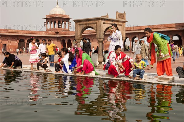 Devout Muslims purifying themselves in the water basin of the Friday Mosque Jama Masjid