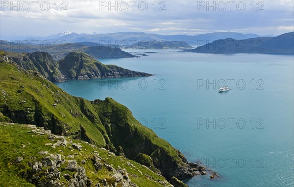 Cruise ship in a bay off the rugged cliffs of Runde island