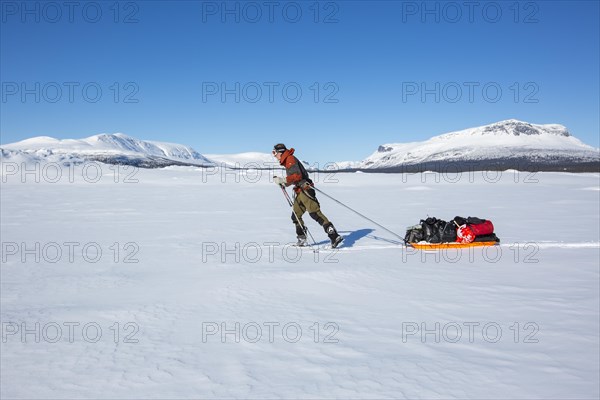 Ski tourers with Pulka in the snow