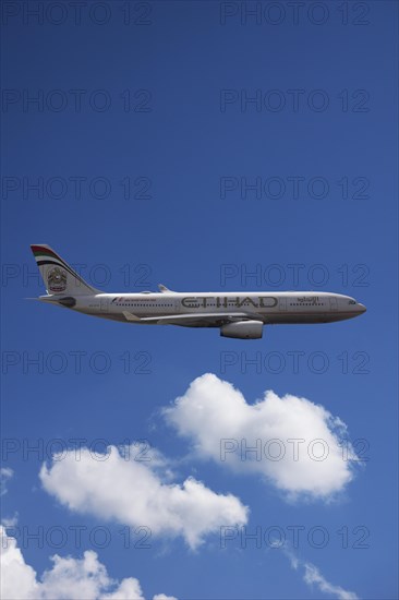 A6-EYK Etihad Airways Airbus A330-243 in flight against a cloudy sky