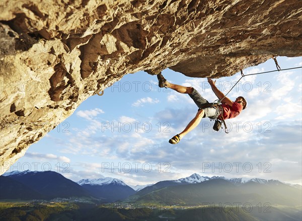 Freeclimber with helmet climbing on a rock face