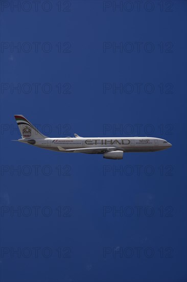 A6-EYK Etihad Airways Airbus A330-243 in flight against a blue sky