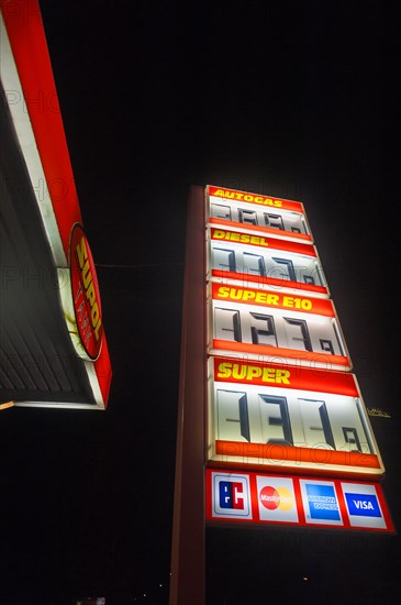 Electronic price list at a filling station against a black night sky