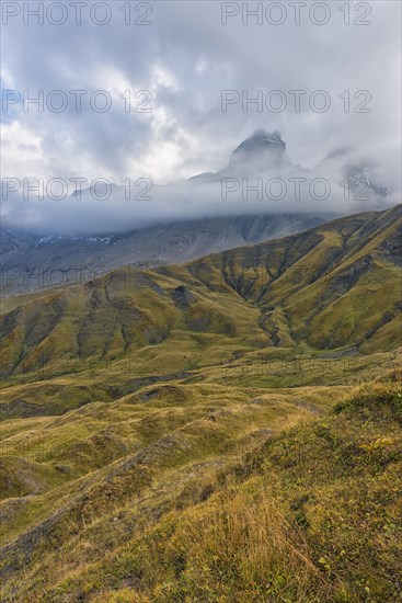 Pelvoux landscape with the Les Aiguilles d'Arves mountain between fog and clouds