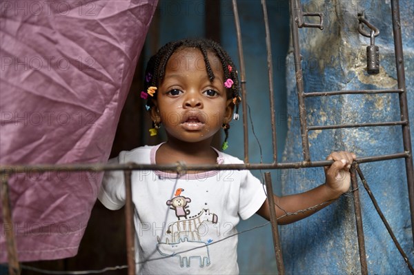 Girl behind a fence in a doorway