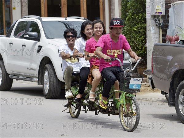 Four teenagers riding a tandem