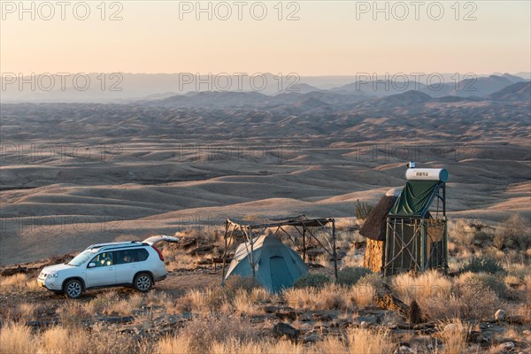 SUV next to tent and small hut