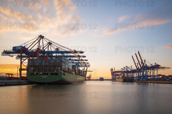 Cargo ships being loaded at Eurokai and Burchardkai in Hamburg Harbour at sunset