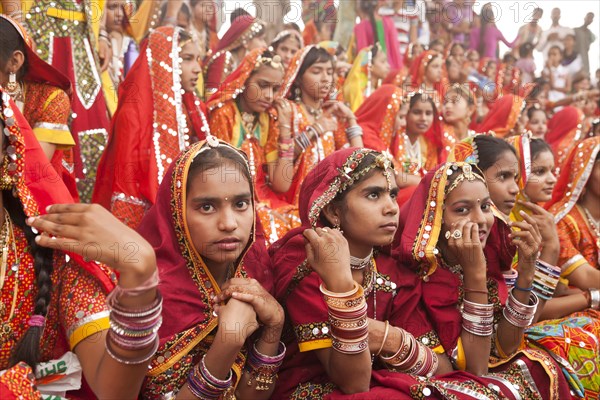 Young women in typical colourful traditional Rajasthani costume at the camel market and livestock market