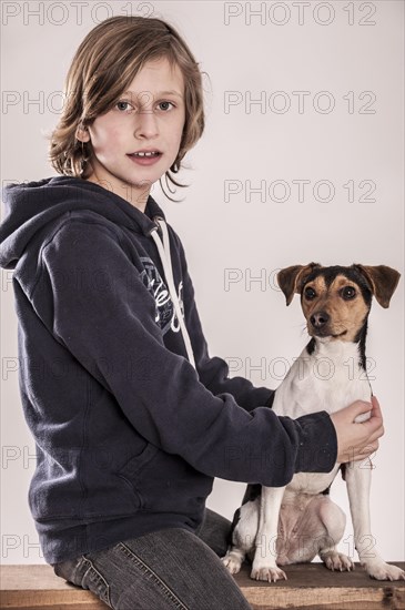 Girl sitting on a bench with a Danish Swedish Farmdog