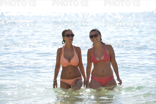 Two young women wearing bikinis in the sea