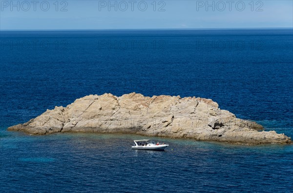 Motorboat in front of rock