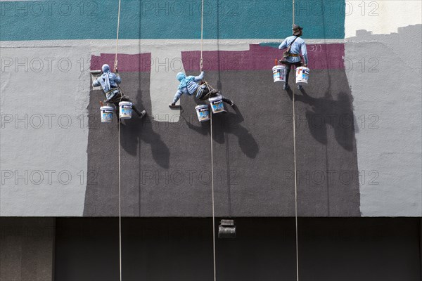 Decorators painting the facade of a high-rise building