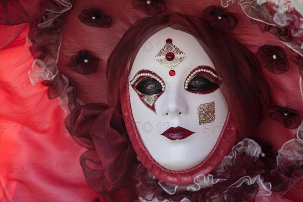 Venetian Carnival mask and costume at the Venetian Fair on the historic market square