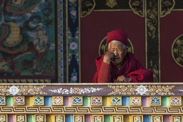 Buddhist monk on the balcony of the Cinya Llama Gompa