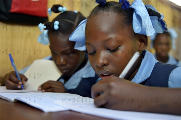 Two girls writing in a notebook