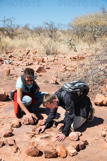 Two tourists looking for fossilised dinosaur footprints