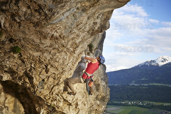 Freeclimber with helmet climbing on a rock face