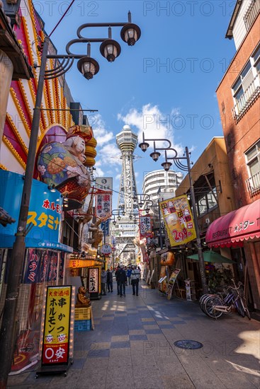 Many colorful advertising signs in a pedestrian zone with shops and restaurants