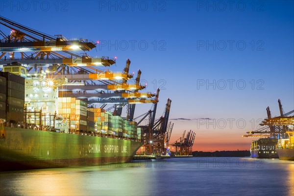 Cargo ships being loaded at Eurokai and Burchardkai in Hamburg Harbour at night