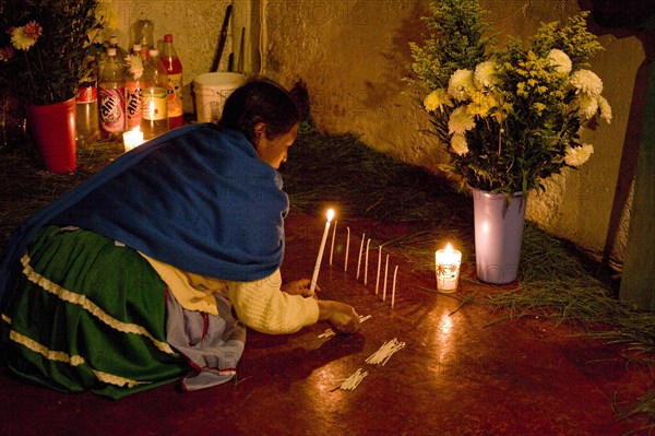 Indigenous Mayan woman lighting candles in a church