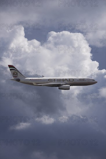 A6-EYK Etihad Airways Airbus A330-243 in flight against a cloudy sky