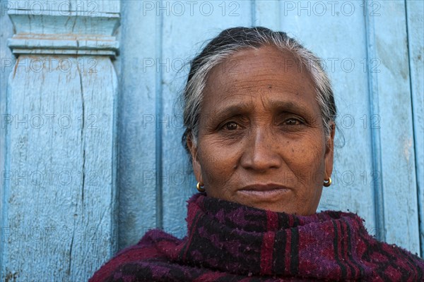 Nepalese woman in front of a blue door