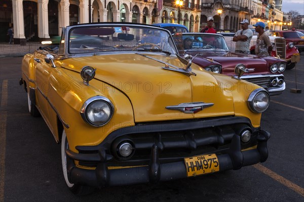 Vintage cars on the Prado at dusk