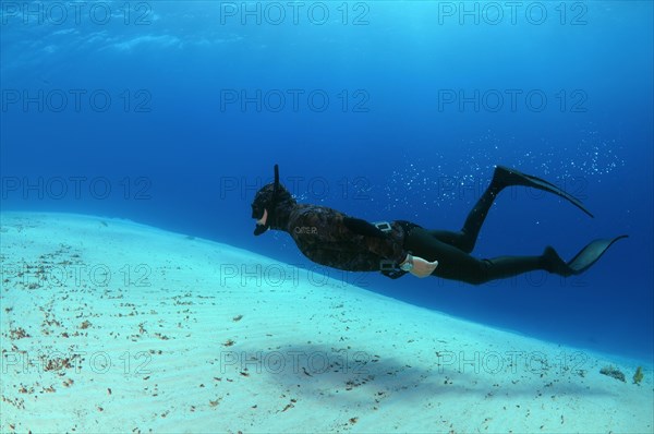 Freediver above sandy bottom