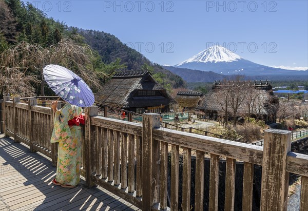 Japanese woman in kimono with paper umbrella in the open-air museum Iyashinosato