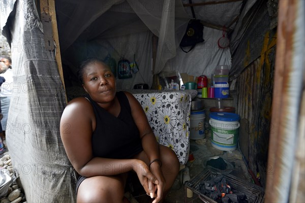 Woman sitting at the entrance to their temporary dwelling