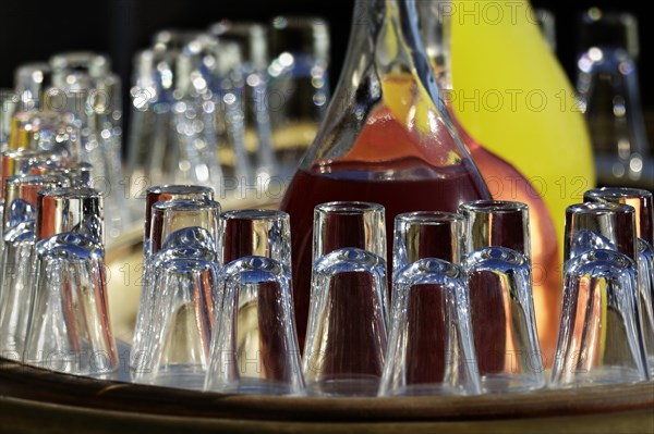 Glasses in front of glass carafes with juices