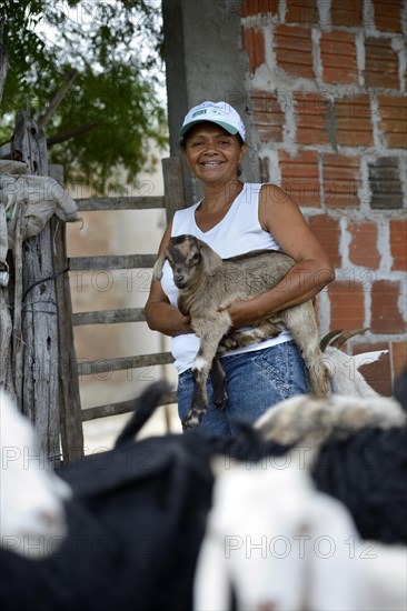 Woman holding a goatling