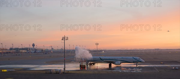 Aircraft de-icing at sunrise