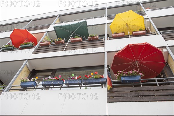 Facade with balconies with flower-boxes and parasols