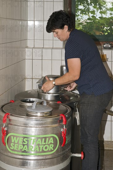 Young farmer filling milk into transport tanks