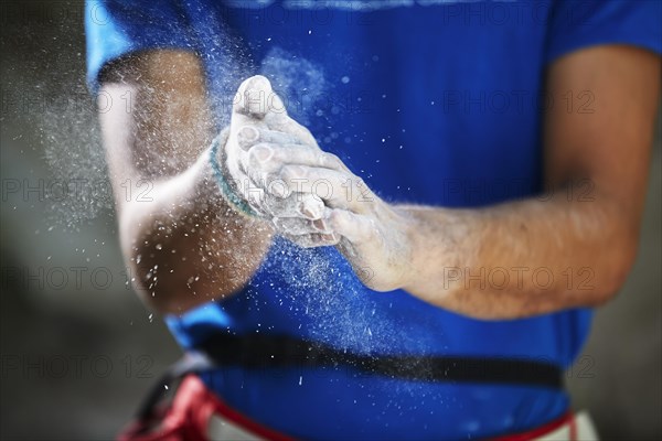 Climber coating his hands with magnesium