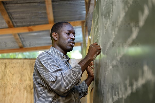 Teacher writing on the blackboard